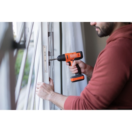 Photo of BLACKDECKER BCD712VHD cordless drill in use installing a door lock.