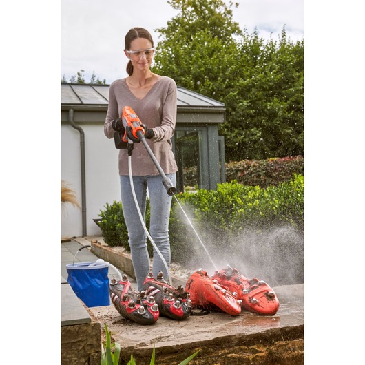 BLACKDECKER BCPC20D1 cordless pressure washer cleaning red sports shoes outdoors.