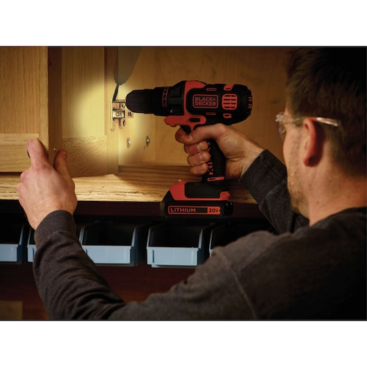 Photo of BLACKDECKER BDCDM6KITC cordless drill with lithium 20V battery being used to assemble a wooden cabinet.