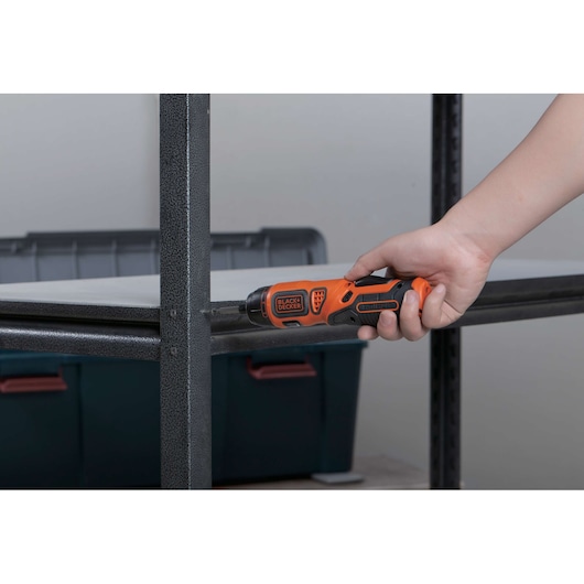 BLACKDECKER BDCS36F cordless screwdriver used on a metal shelf, close-up of tool in hand.