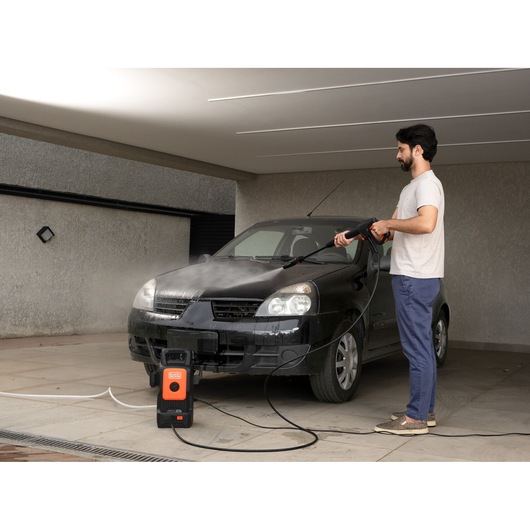 BLACKDECKER BEPW1520 pressure washer used to clean black car in driveway.