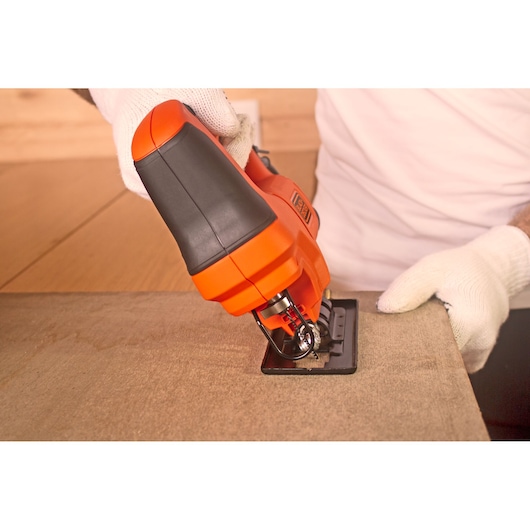 BLACKDECKER BES603 jigsaw in use cutting wood, close-up photography showing ergonomic handle.