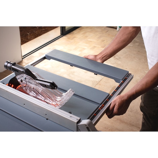 BLACKDECKER BES71800TSS table saw with blade guard, shown in use from top angle.
