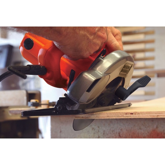 Photo of BLACKDECKER CS1004 circular saw cutting wood, close-up view showing blade and orange handle.