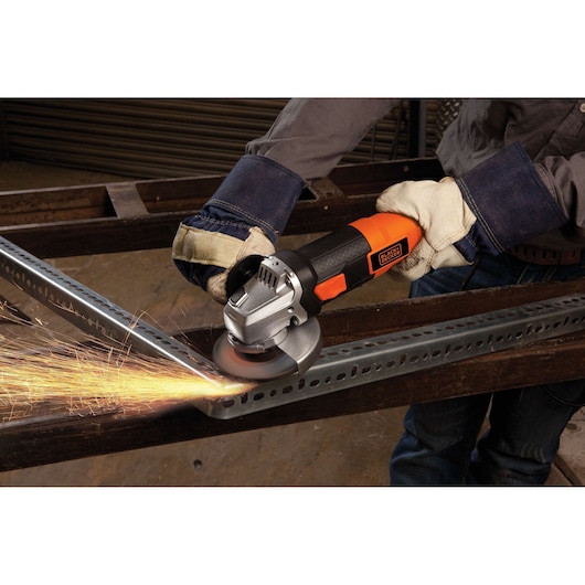 BLACKDECKER G720 angle grinder in use, cutting metal with sparks flying, close-up view.