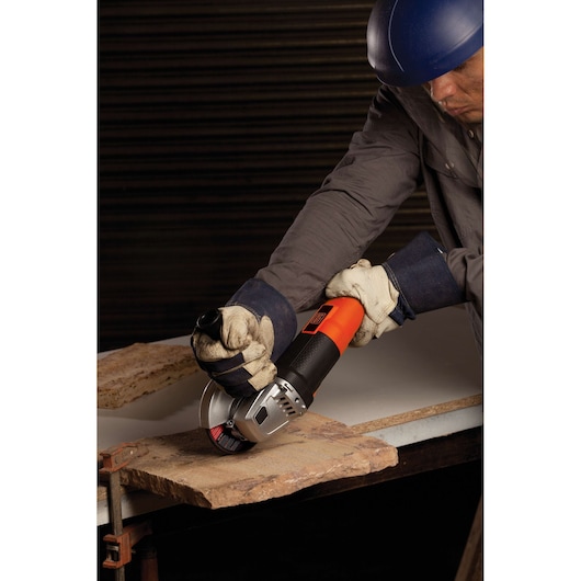 BLACKDECKER G720 angle grinder in use, cutting stone slab, close-up, orange and black body.