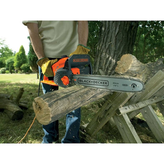 BLACK+DECKER GK1740 electric chainsaw cutting a log outdoors, close-up action view.
