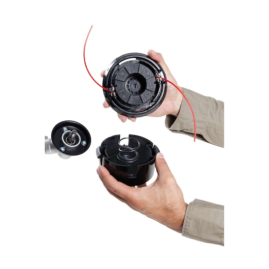 BLACKDECKER GST43 grass trimmer spool assembly held in hands, black plastic parts with red trimmer line, front view.