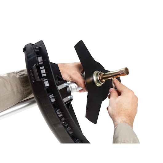 BLACKDECKER GST43 grass trimmer blade assembly close-up, hands attaching metal blade, white background.