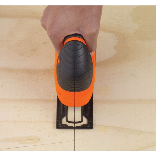 Photo of BLACKDECKER KS501 jigsaw in use cutting a wooden board, top view showing orange and black handle.