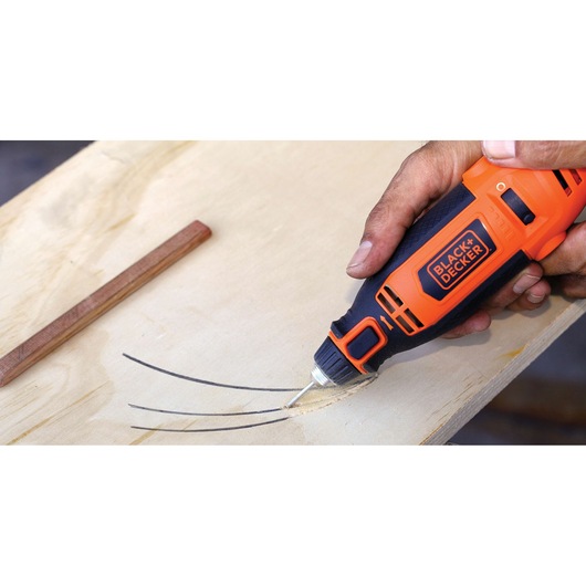 BLACKDECKER RT18KA rotary tool engraving a curved line on light wood surface, close-up photo.