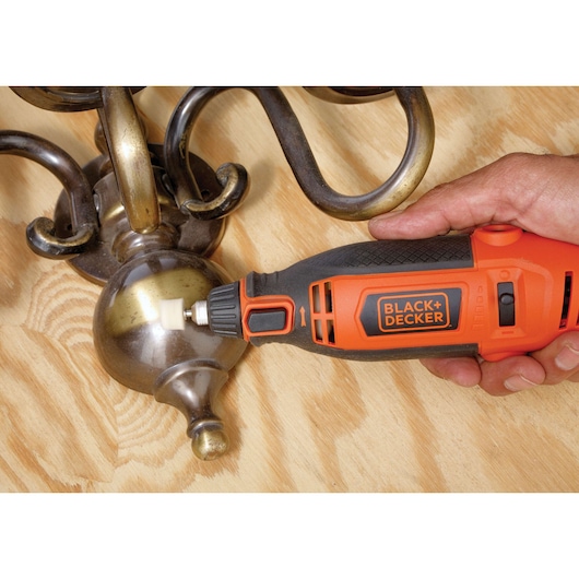 Photo of BLACK+DECKER RT18KA rotary tool being used to polish a brass fixture on a wooden surface.