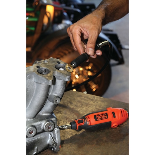 Photo of BLACKDECKER RT18KA rotary tool being used to grind a metal part, tool is orange and black.